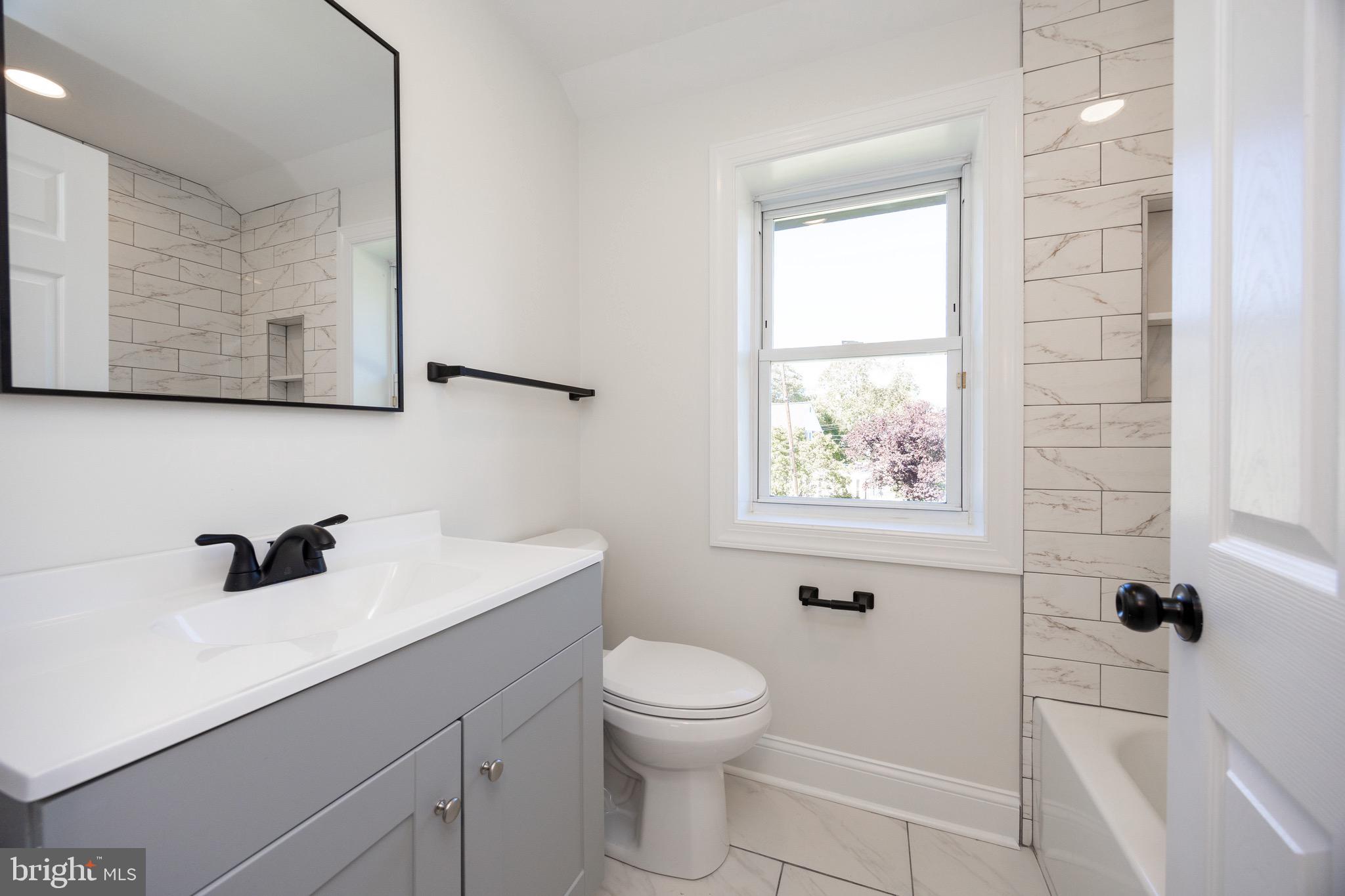 428 Adair Road Holmes, PA 19043 - Photo 29 of 59 a bathroom with a toilet a sink a window and mirror