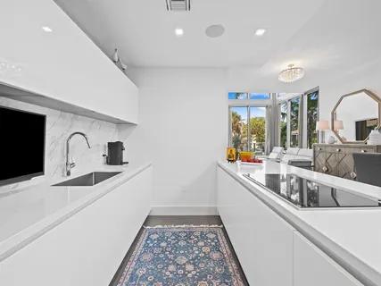 a kitchen with stainless steel appliances granite countertop a sink and dishwasher with white countertops