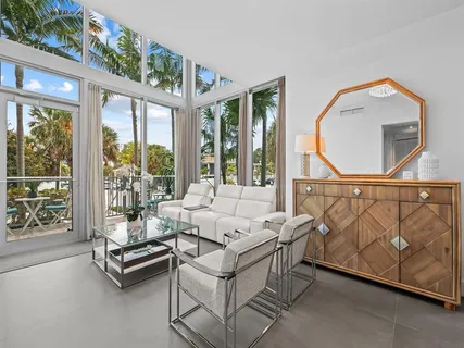 a living room with furniture wooden floor and a large window