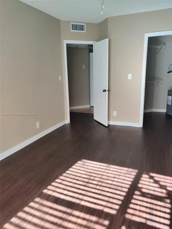 a view of a bedroom with wooden floor and cabinet