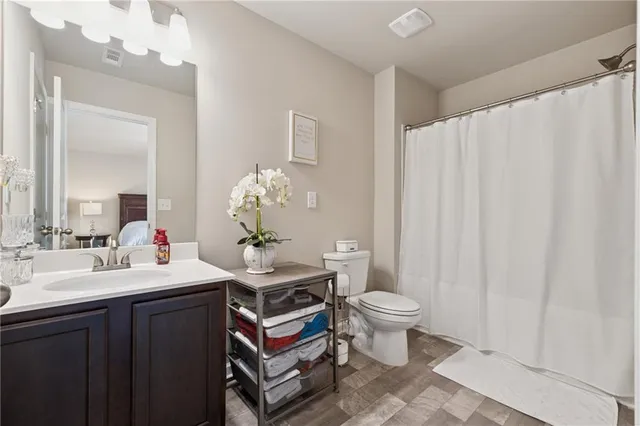 a bathroom with a sink vanity mirror and toilet