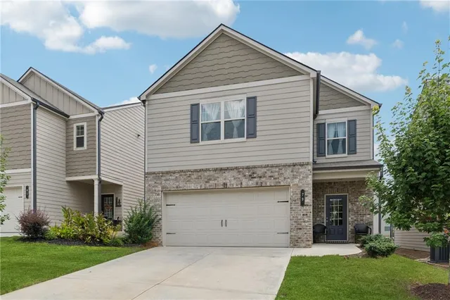 a front view of a house with a garden and plants