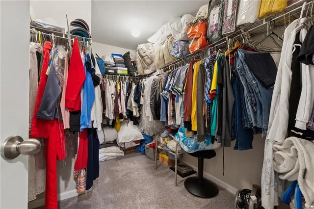 a view of walk in closet with clothes and shoes
