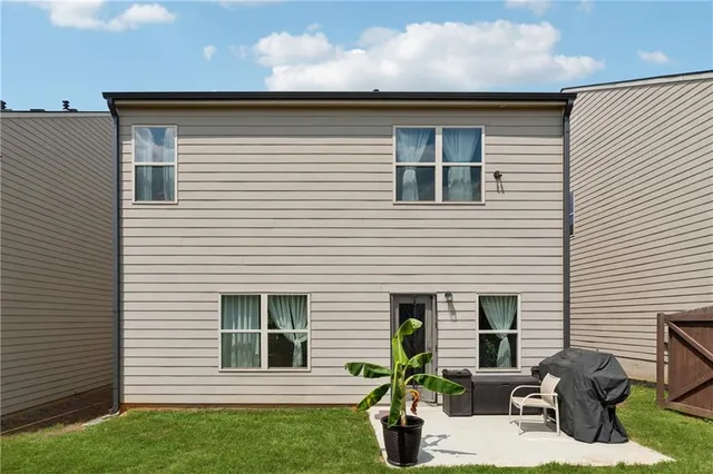 a view of backyard of house with outdoor seating and trees