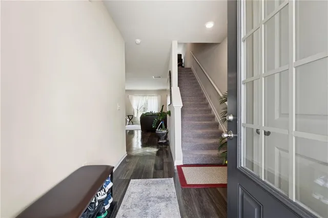 a view of a hallway with wooden floor and staircase