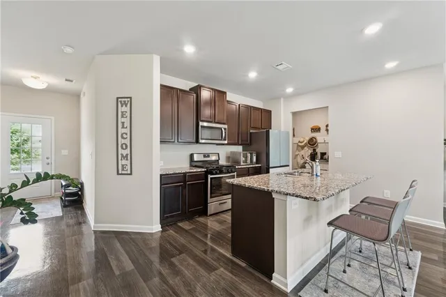a kitchen with stainless steel appliances granite countertop a refrigerator and a stove top oven