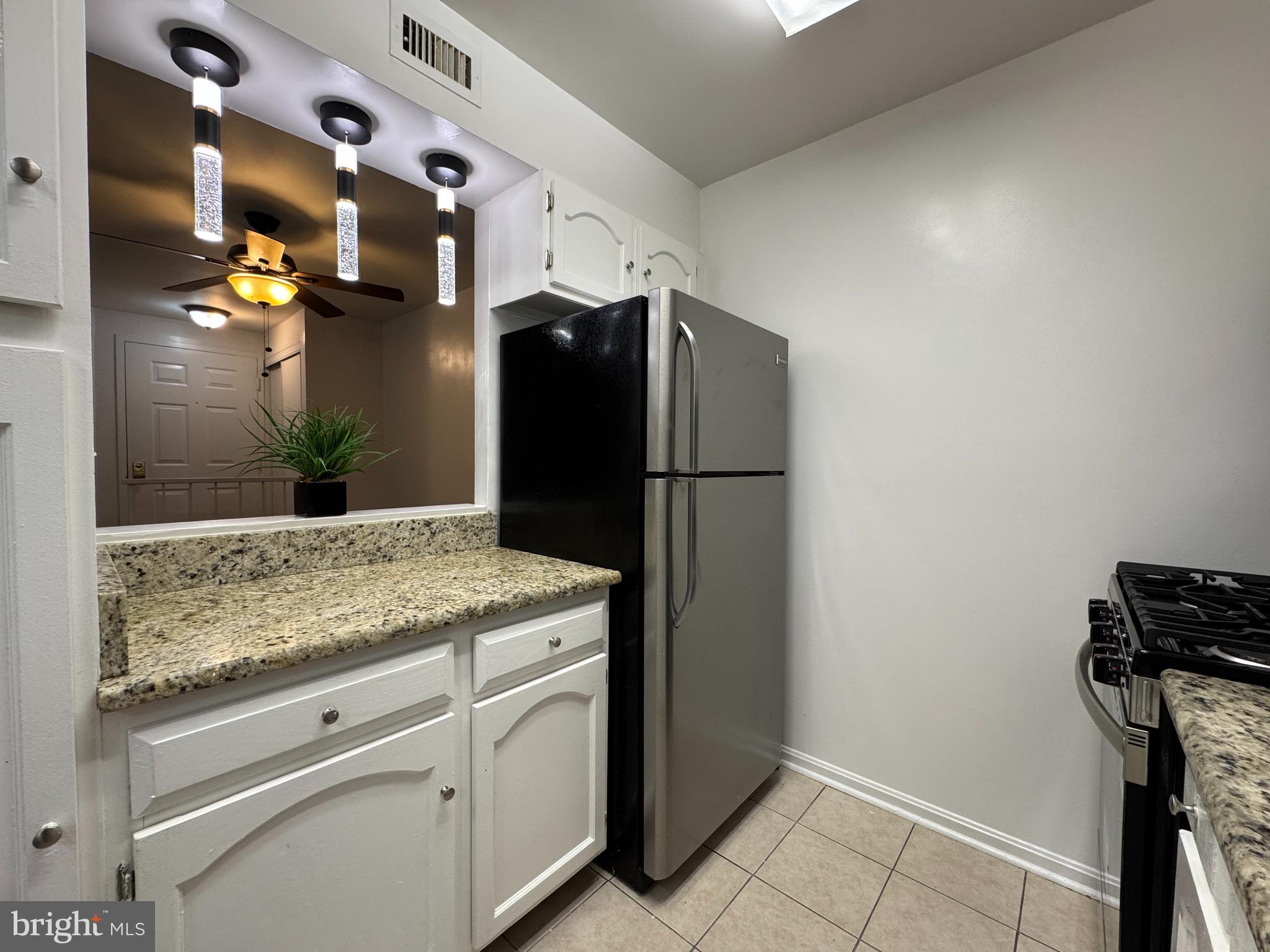 5916 Cove Landing Road, Unit 204 Burke, VA 22015 - Photo 13 of 20 a kitchen with a refrigerator and countertop