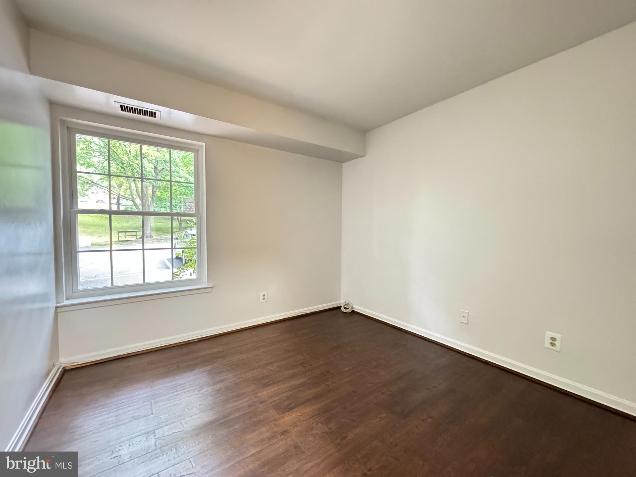5916 Cove Landing Road, Unit 204 Burke, VA 22015 - Photo 18 of 20 an empty room with wooden floor and windows
