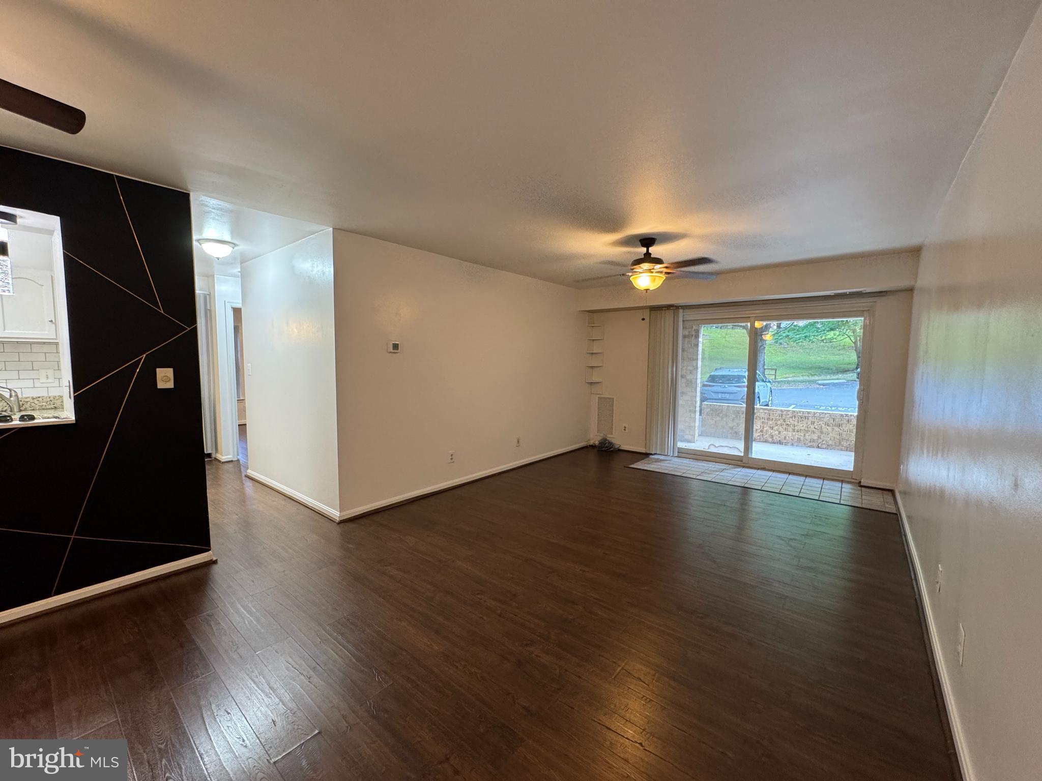 5916 Cove Landing Road, Unit 204 Burke, VA 22015 - Photo 3 of 20 a view of an empty room with wooden floor and a window