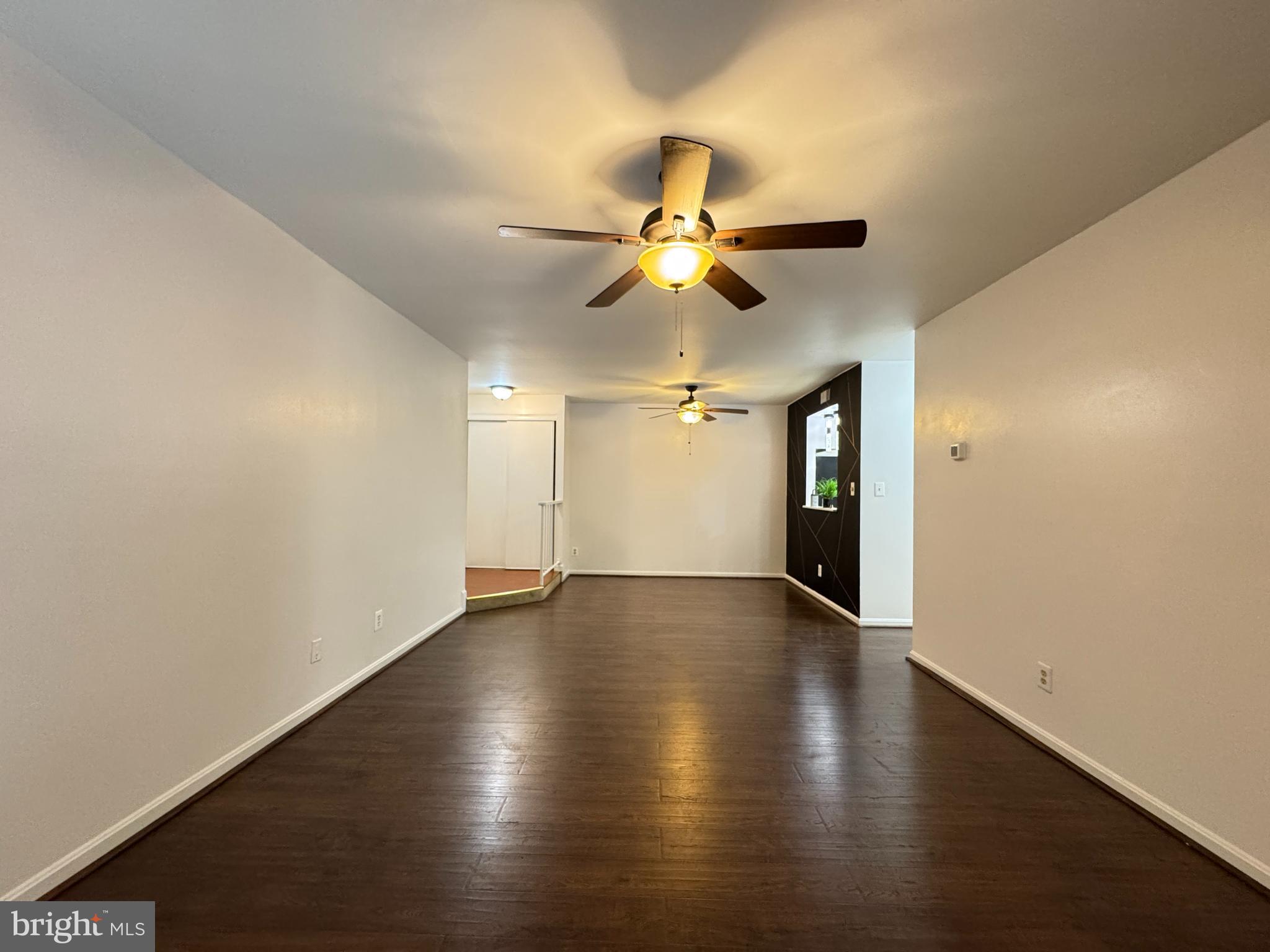 5916 Cove Landing Road, Unit 204 Burke, VA 22015 - Photo 7 of 20 an empty room with wooden floor chandelier fan and closet area