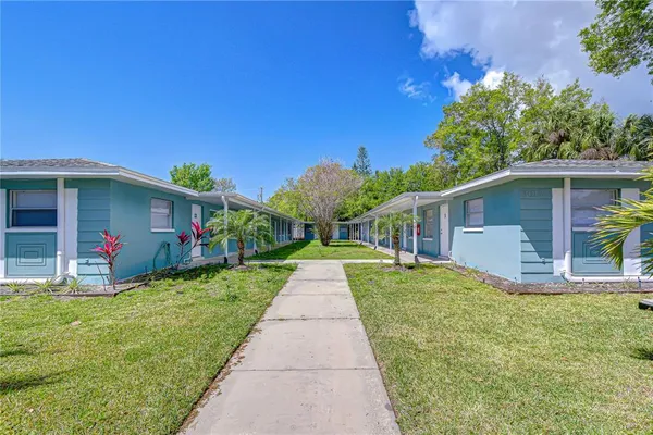 a front view of a house with a yard and potted plants