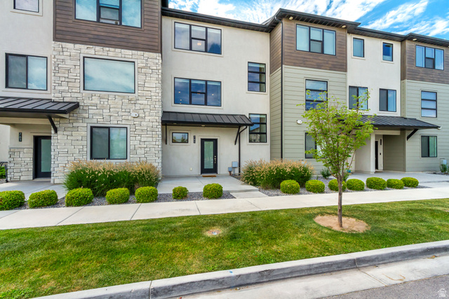 765 Crystal Crk Road American Fork, UT 84003 - Photo 2 of 27 Contemporary townhome exterior featuring a stucco siding, dark frame windows, and a covered entry