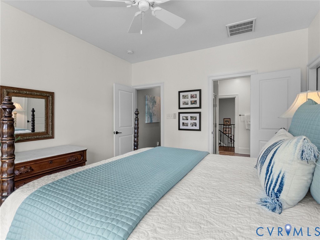 16131 Binley Road Midlothian, VA 23112 - Photo 76 of 99 a bedroom with a large bed and a chandelier