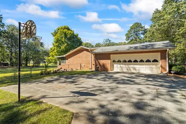 a view of a house with backyard and trees