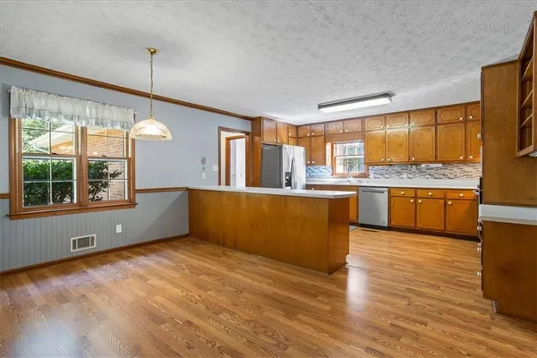 a view of a kitchen with wooden floor and a window