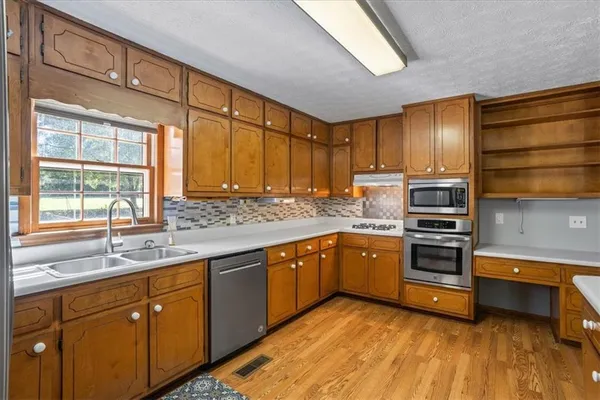 a kitchen with stainless steel appliances sink cabinets and window