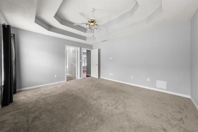 a view of an empty room with a chandelier fan