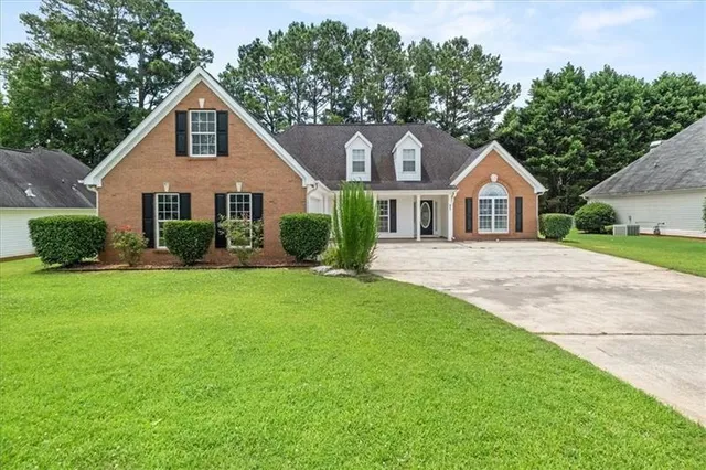 a front view of a house with a garden and plants