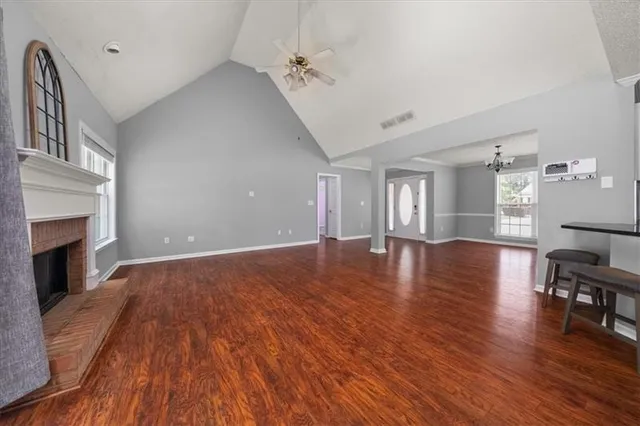a view of empty room with wooden floor and fireplace