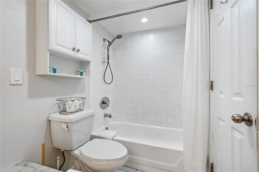 230 Medallion Boulevard, Unit E Madeira Beach, FL 33708 - Photo 15 of 35 a bathroom with a toilet a sink and bathtub