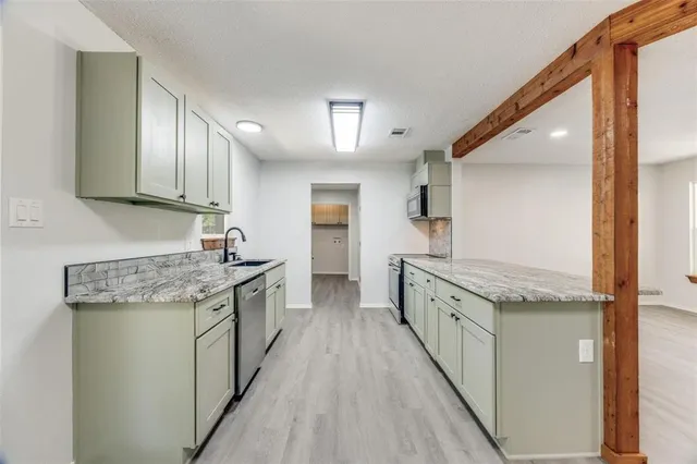 a kitchen with granite countertop a sink and cabinets