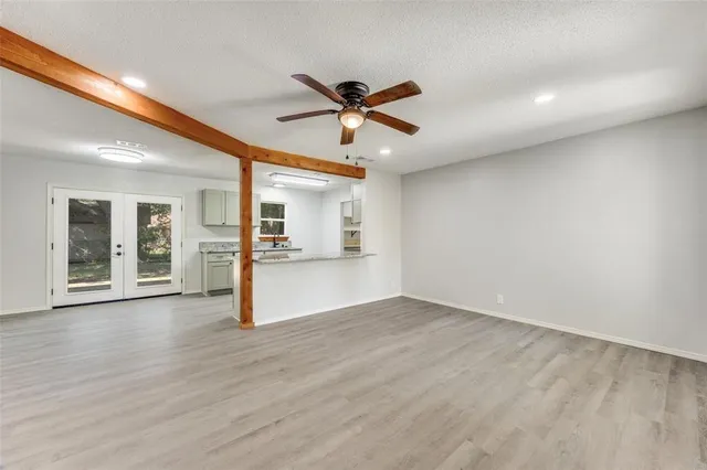 a view of a livingroom with wooden floor and a ceiling fan