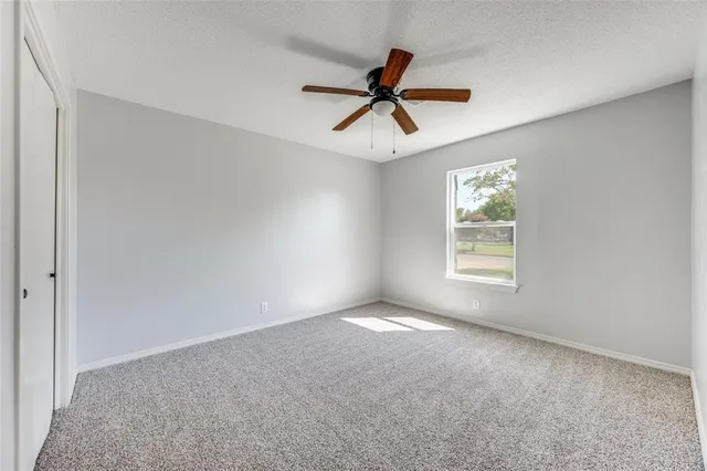 a view of room with a window and a ceiling fan
