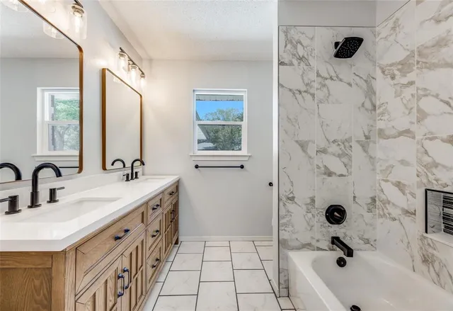 a bathroom with a double vanity sink a mirror and shower
