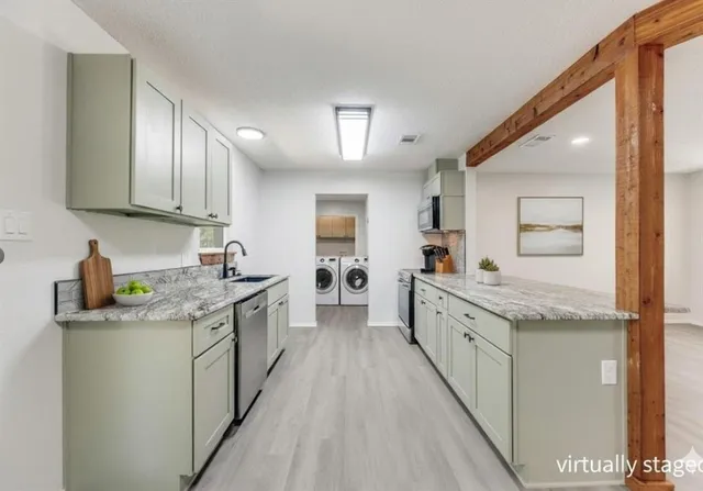 a large kitchen with granite countertop kitchen island a sink stainless steel appliances and cabinets