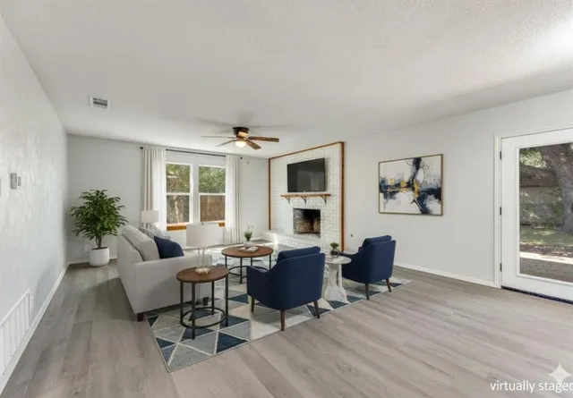 a living room with furniture wooden floor and a potted plant