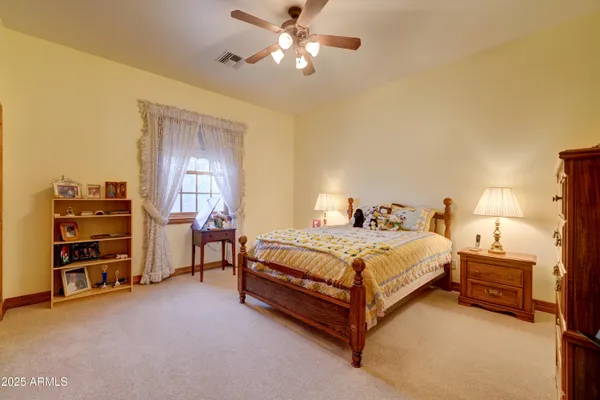 a spacious bedroom with a bed and a chandelier