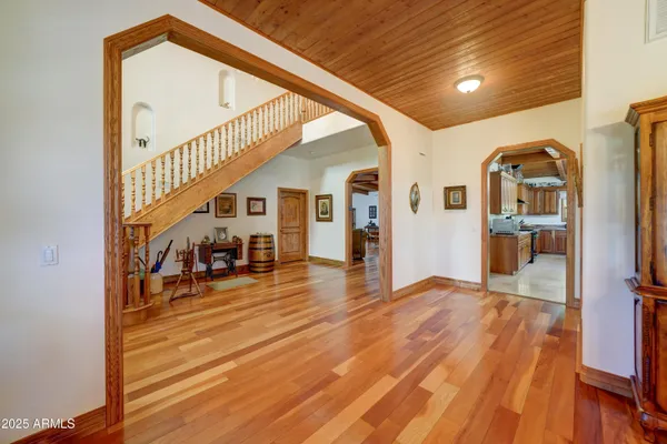 a view of a hallway with wooden floor and staircase