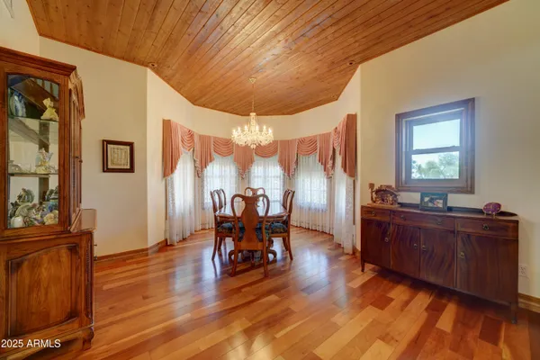 a dining room with wooden floor and furniture