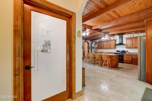 a room with stainless steel appliances kitchen island granite countertop a refrigerator and a wooden cabinets