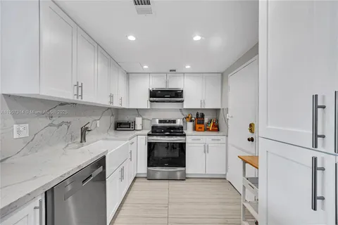 a kitchen with stainless steel appliances granite countertop a stove and a sink