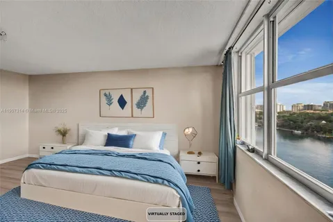 a bedroom with a large bed and a painting on the wall