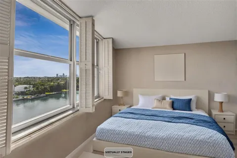 a bedroom with a large bed and a large window with outer view