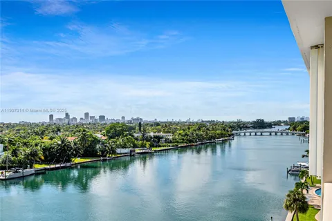 a view of ocean with boats and trees in the background
