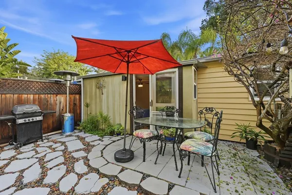 a view of a patio with a table and chairs under an umbrella