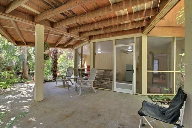 a living room with patio furniture and a large window