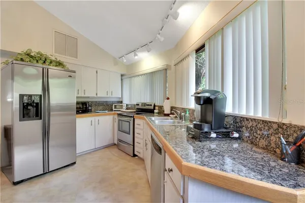 a kitchen with white cabinets and appliances