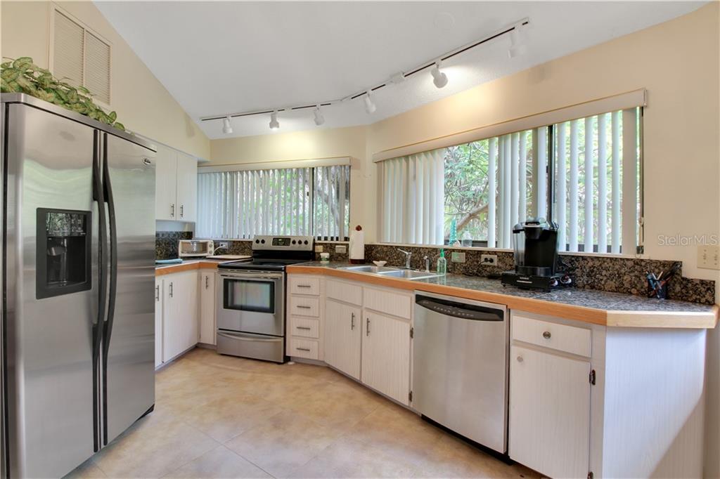8335 Manasota Key Road Englewood, FL 34223 - Photo 8 of 27 a kitchen with white cabinets and appliances
