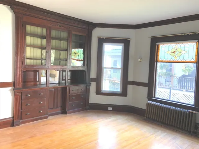 an empty room with windows cabinet and balcony