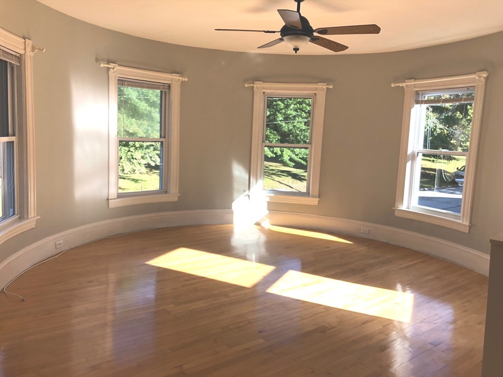 505 High Street, Unit 505 Lowell, MA 01852 - Photo 2 of 17 a view of an empty room with wooden floor and a window