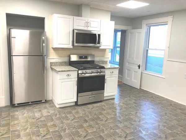 a kitchen with a stove a refrigerator and a sink