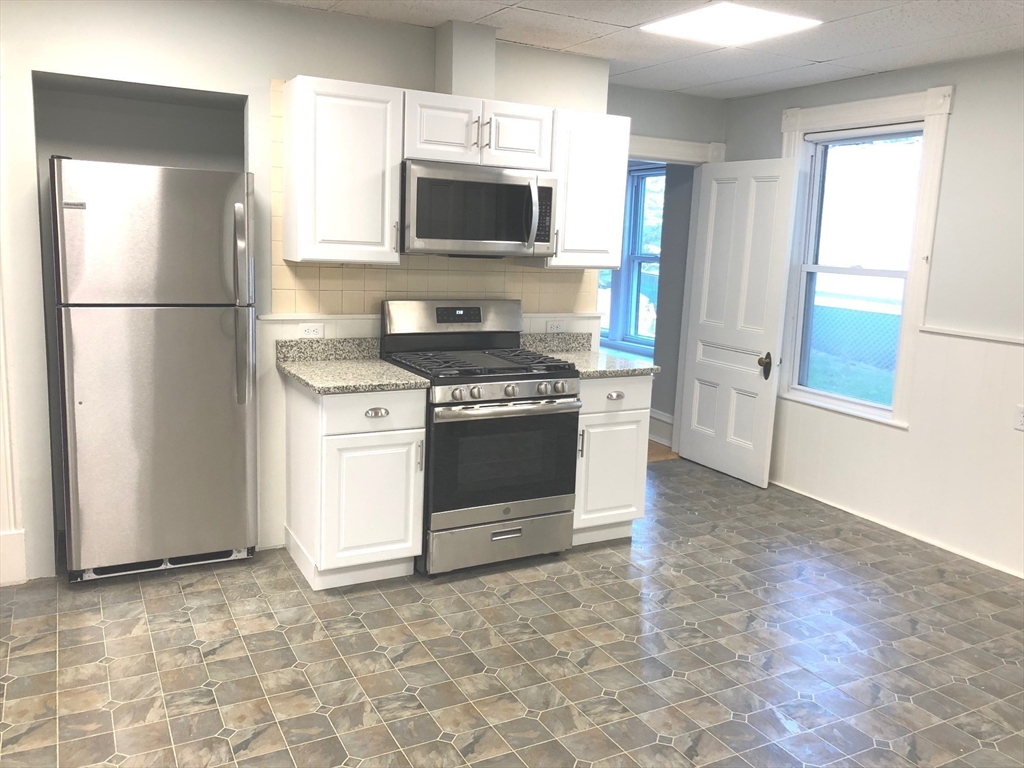 505 High Street, Unit 505 Lowell, MA 01852 - Photo 8 of 17 a kitchen with a stove a refrigerator and a sink