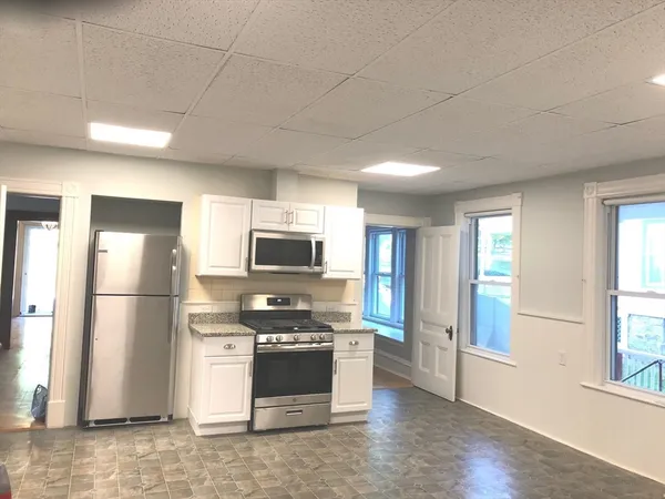a kitchen with stainless steel appliances a refrigerator a stove a sink and a window