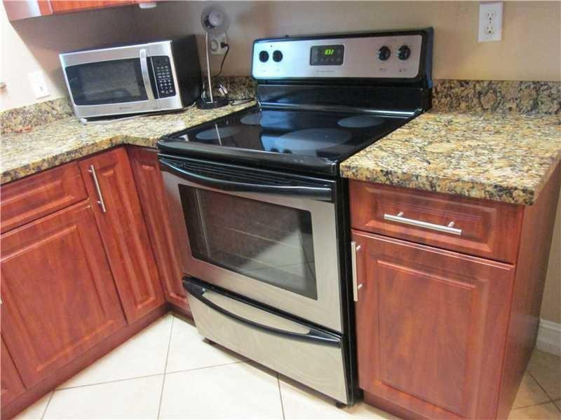 1925 Madison Street, Unit 4 Hollywood, FL 33020 - Photo 5 of 11 a stove top oven sitting inside of a kitchen