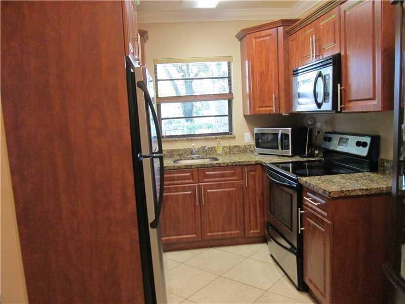 1925 Madison Street, Unit 4 Hollywood, FL 33020 - Photo 6 of 11 a kitchen with stainless steel appliances granite countertop a refrigerator and a sink