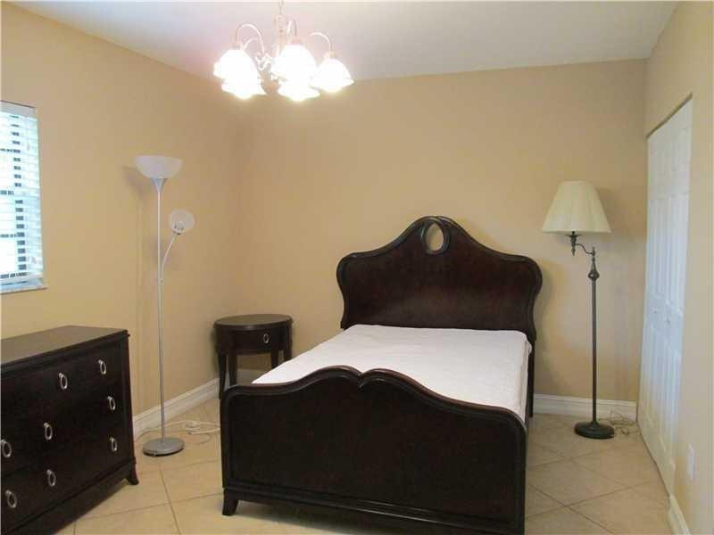 1925 Madison Street, Unit 4 Hollywood, FL 33020 - Photo 8 of 11 a bedroom with a bed and a chandelier